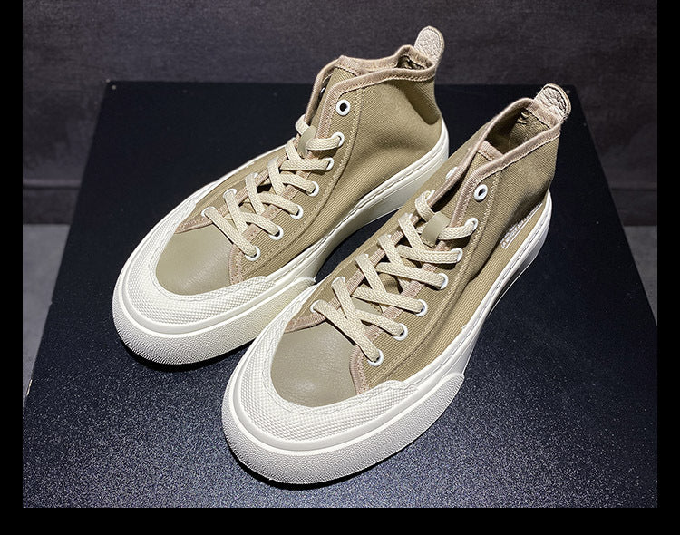 Pair of beige high-top sneakers on a black background