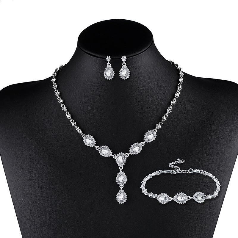 Silver jewelry set with necklace, earrings, and bracelet on a black mannequin bust.