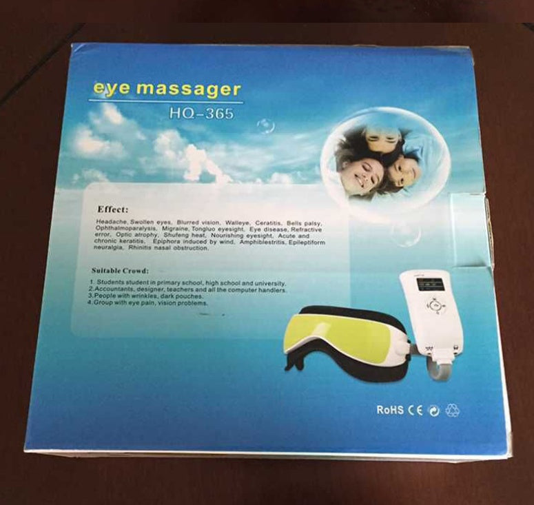Box of an eye massager with text and images on a wooden surface