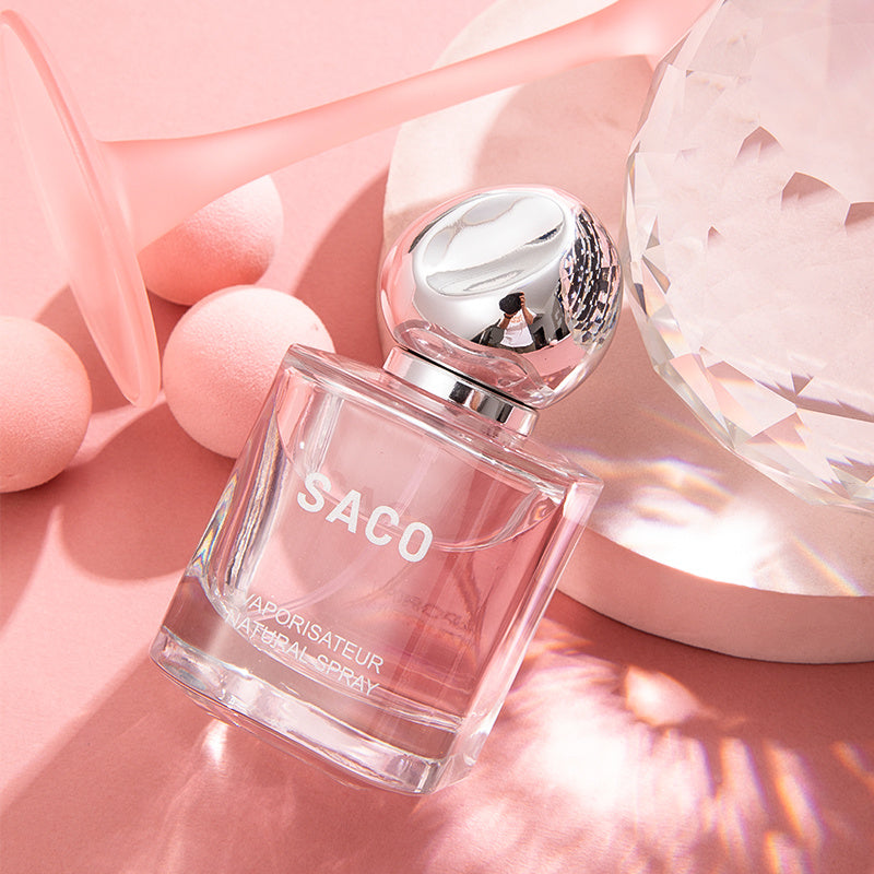 Perfume bottle labeled 'SACO' on a pink background