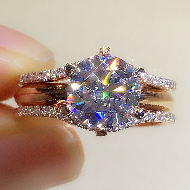 Close-up of a diamond ring held between fingers with a light background
