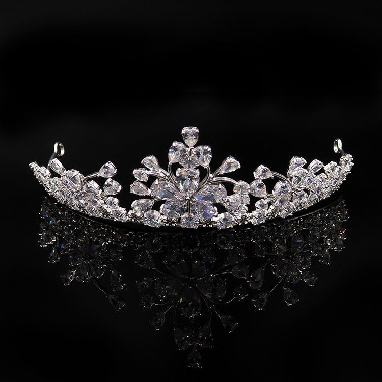 Silver tiara with intricate design on a black background