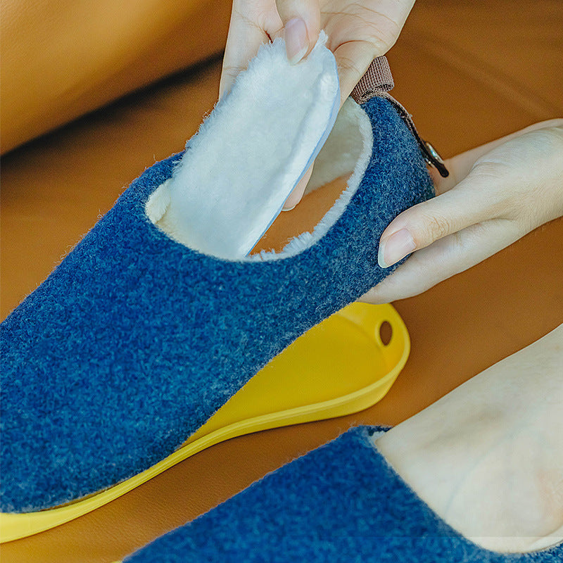 Blue slippers with a yellow sole being worn by a person.