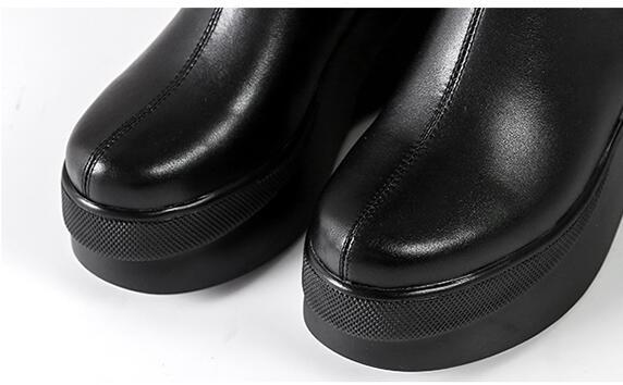 Close-up of black platform shoes on a white background