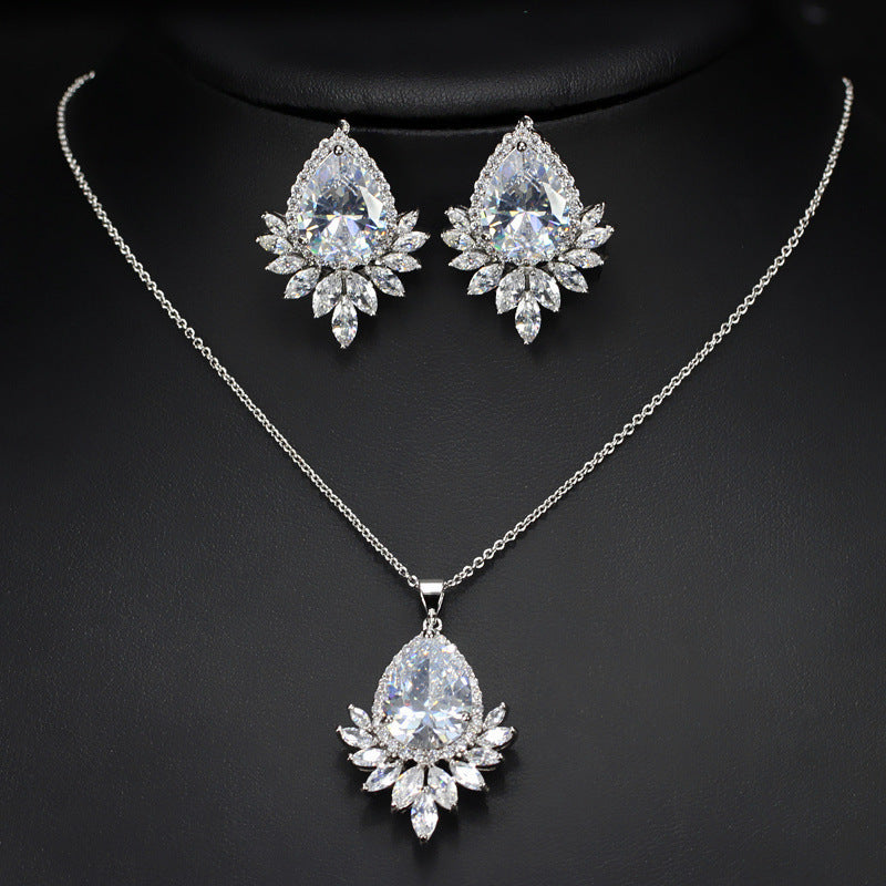 Jewelry set with necklace and earrings featuring teardrop-shaped crystals on a dark background