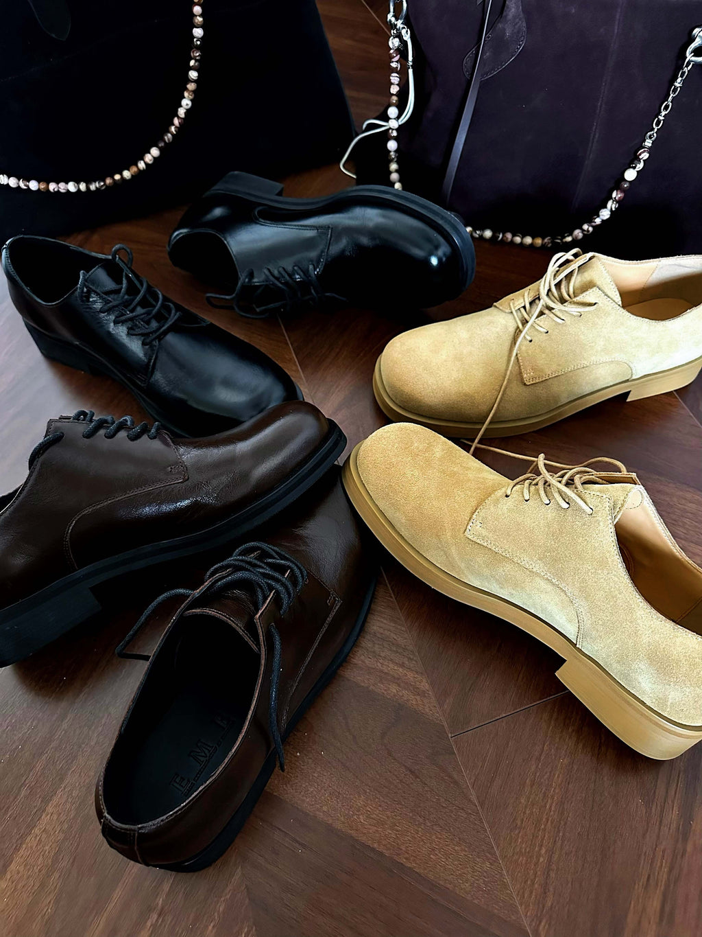 Pair of black and brown leather shoes on a wooden floor.
