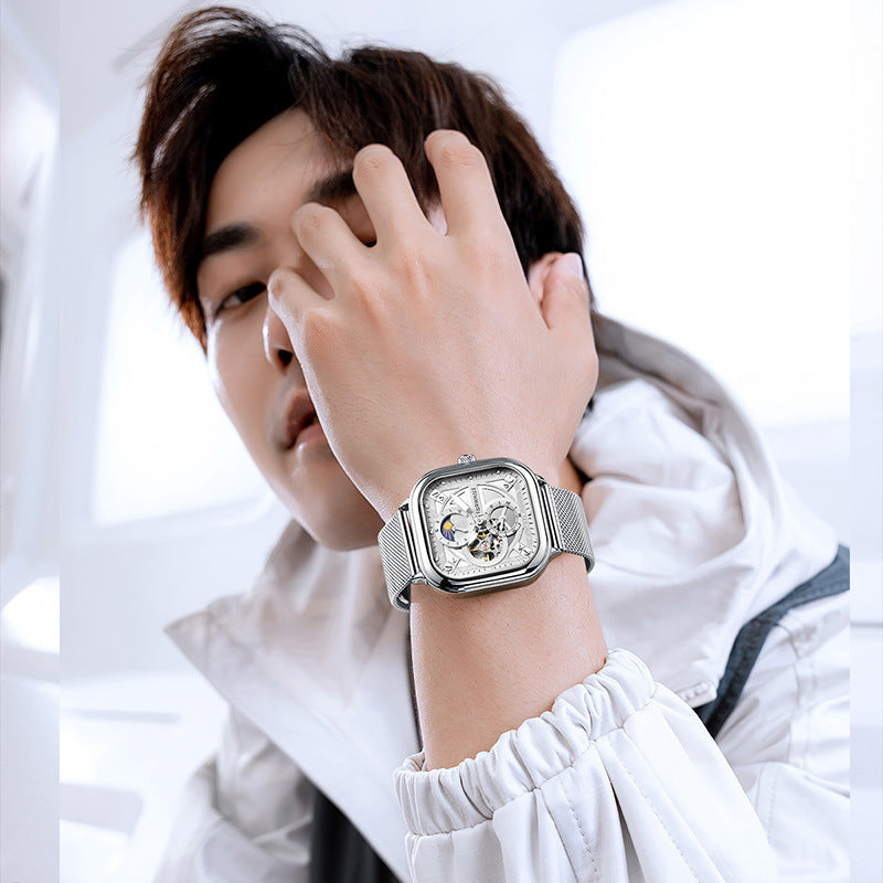Person wearing a silver watch with a white background