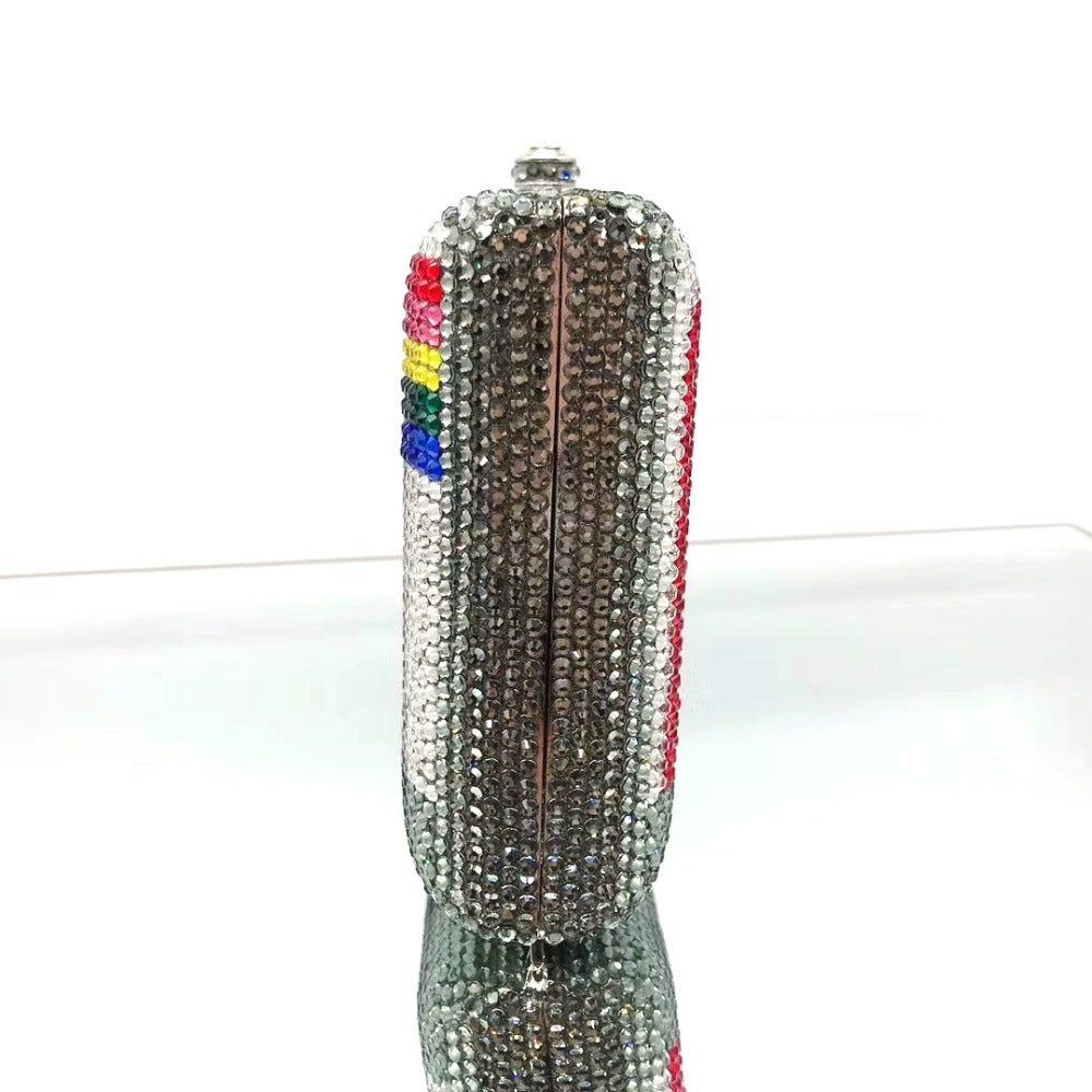 Decorative feather with rhinestones and a rainbow-colored tip on a white background