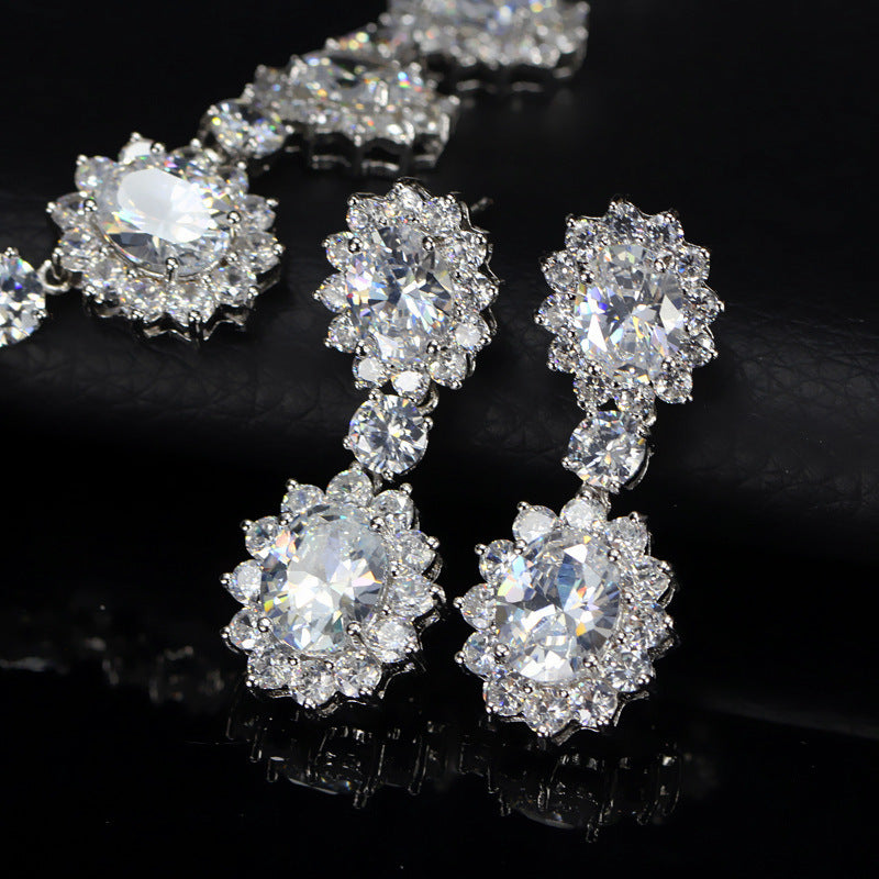 Silver floral earrings with clear gemstones on a black background