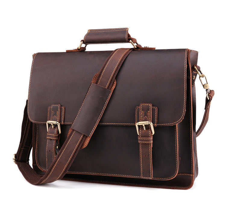 Brown leather satchel bag with gold buckles on a white background