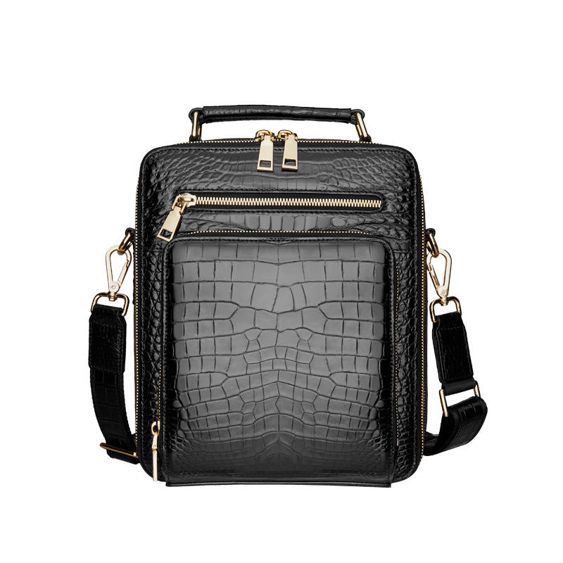 Black crocodile-patterned handbag with gold zippers on a white background