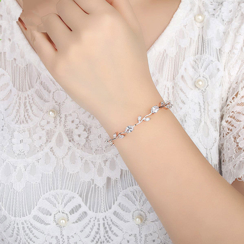 Delicate bracelet on a wrist with a white lace background