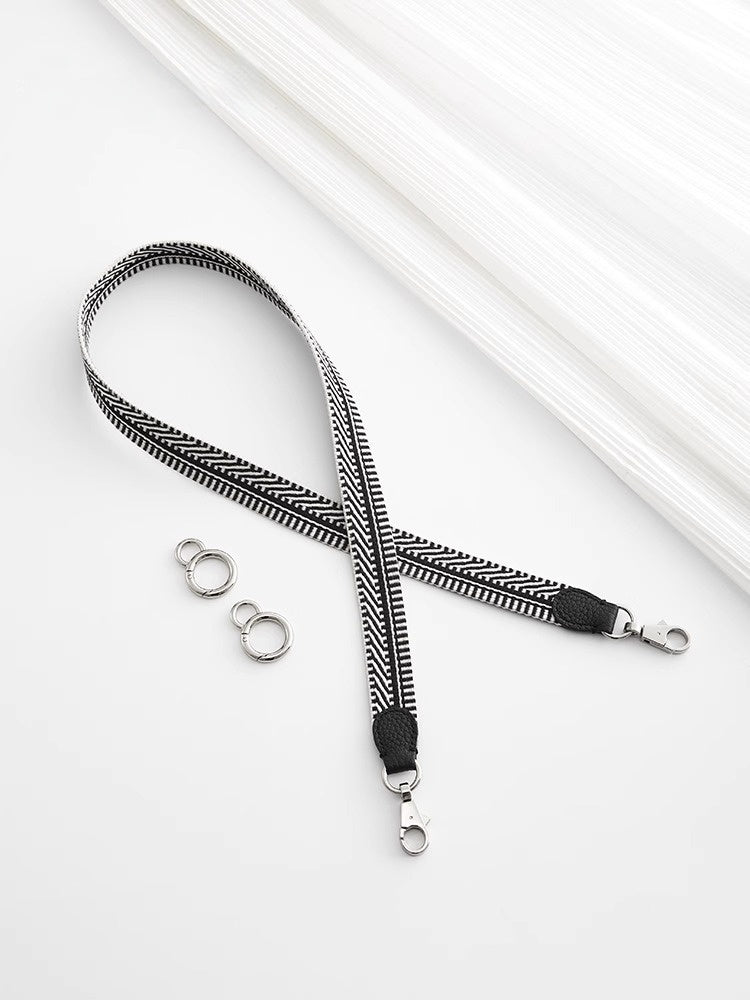Black and white striped lanyard with metal hooks on a white background