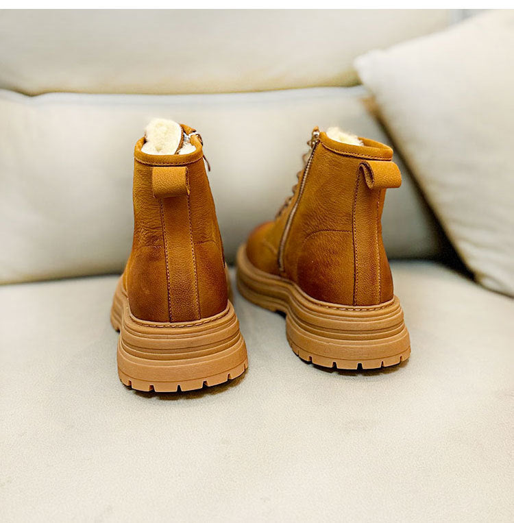 Pair of brown boots with fur lining on a light-colored couch.