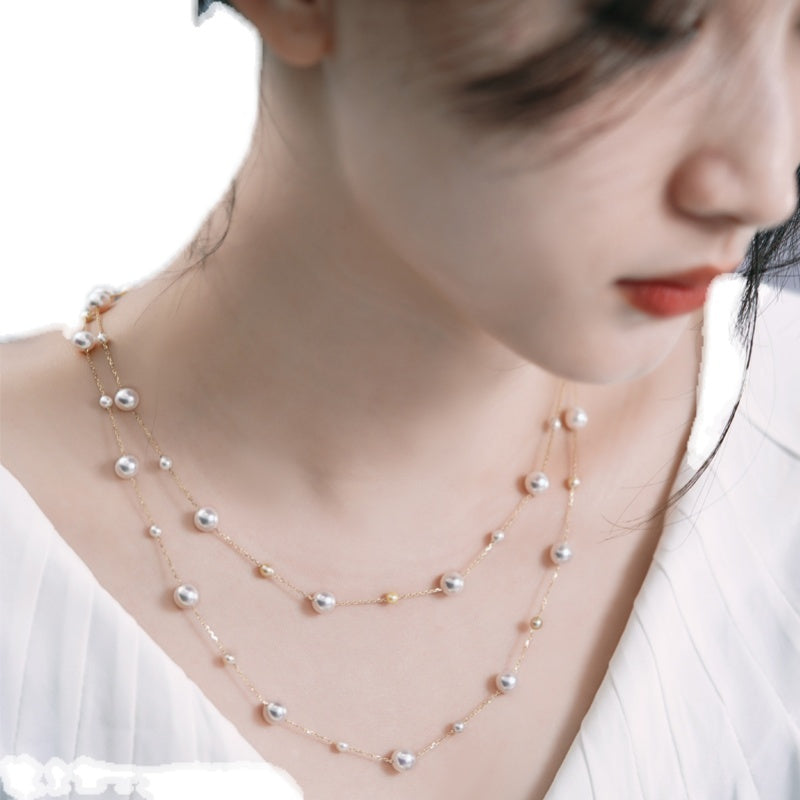 Pearl necklace worn by a person on a white background