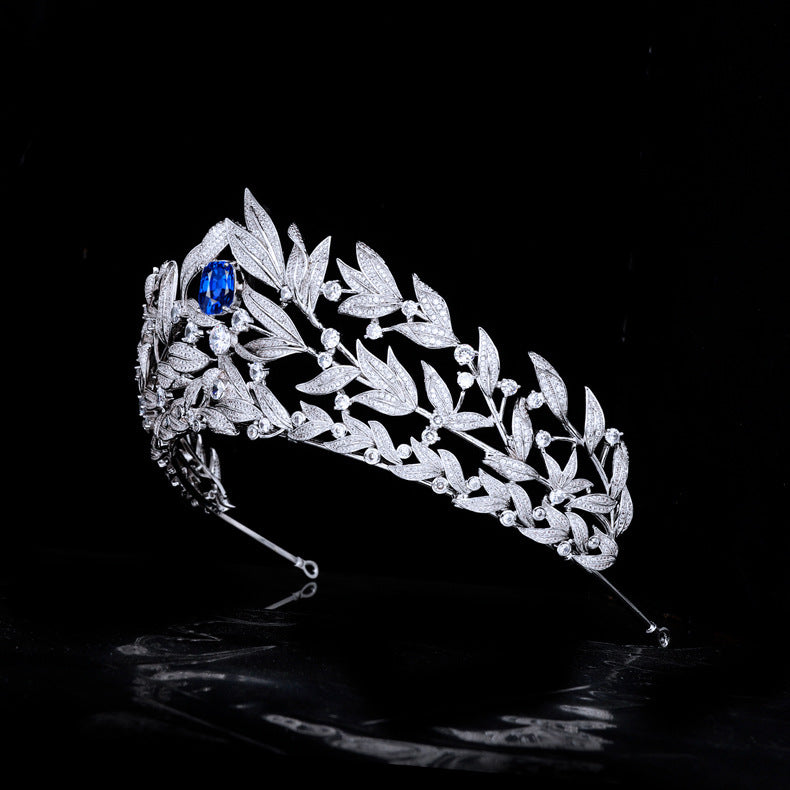 Silver tiara with blue gemstone on a black background