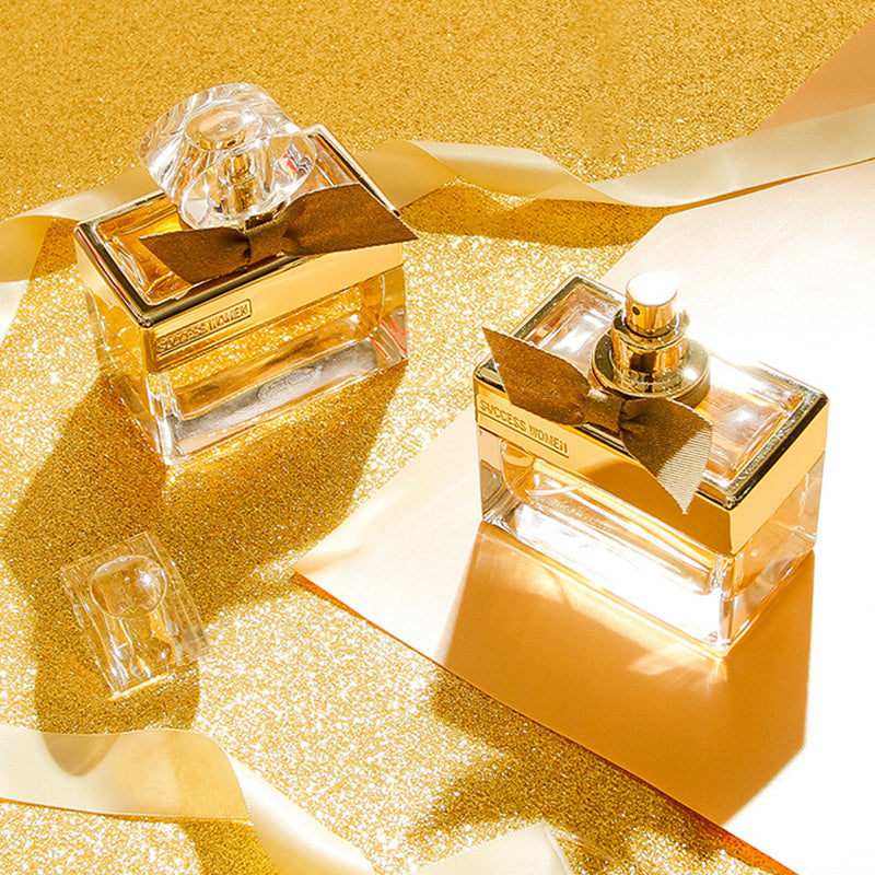 Two gold perfume bottles on a glittery gold background