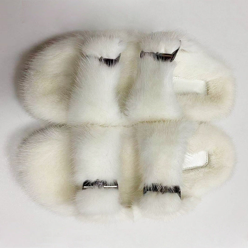 Pair of white fur gloves with metallic clasps on a light gray background