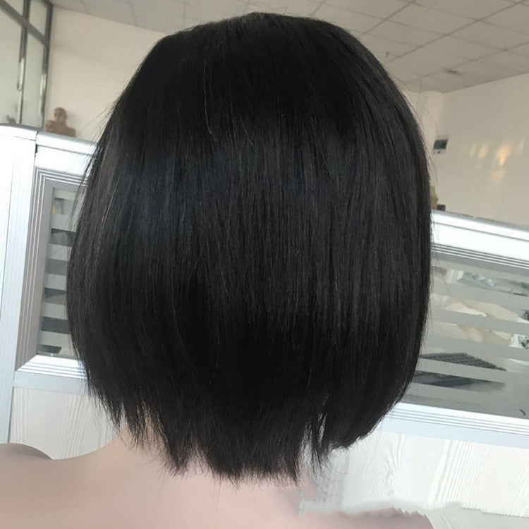 Back view of a person with short black hair in a bathroom setting