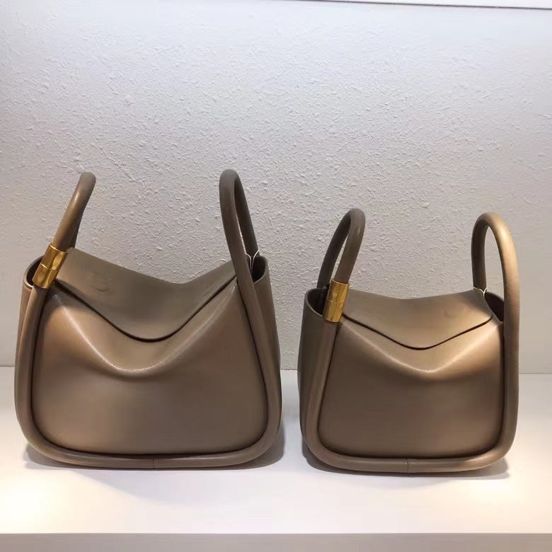 Two brown handbags with gold accents on a white background