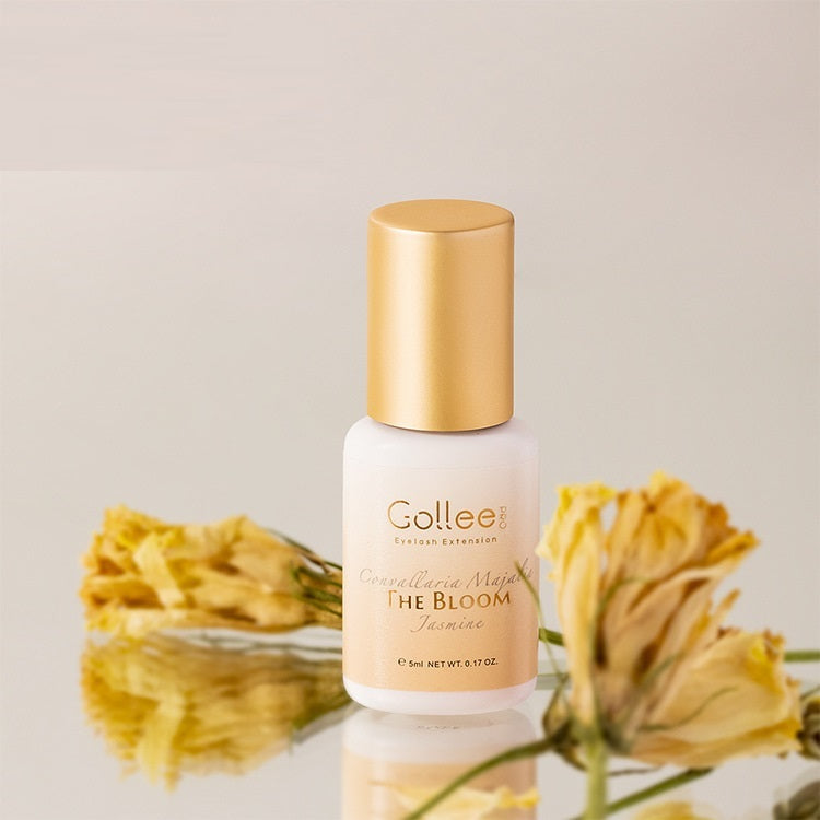 Gollee hair extension product with gold cap and label, surrounded by dried flowers on a light background