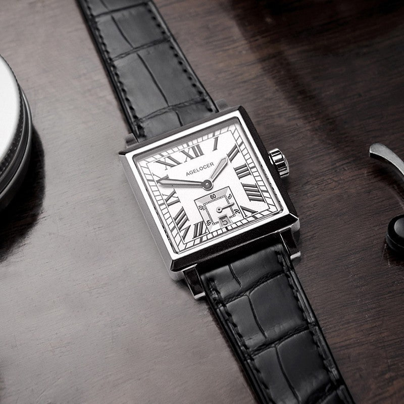 Watch with black leather strap and silver case on a wooden surface