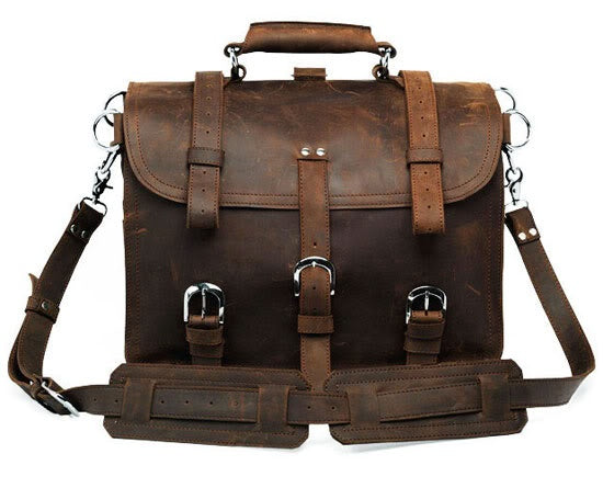 Brown leather satchel bag with multiple straps and buckles on a white background