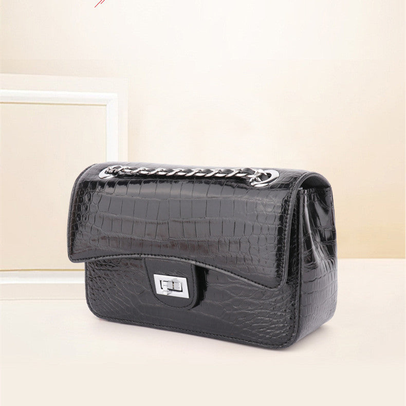 Black crocodile-patterned handbag on a light background