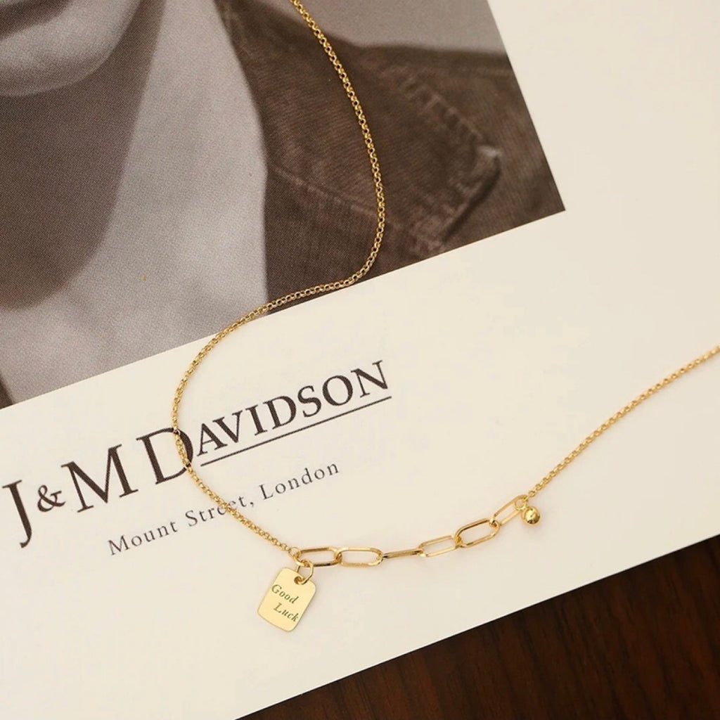 Gold necklace with a tag on a J&M Davidson branded card