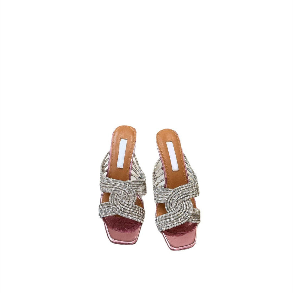 Pair of woven sandals with pink soles on a white background