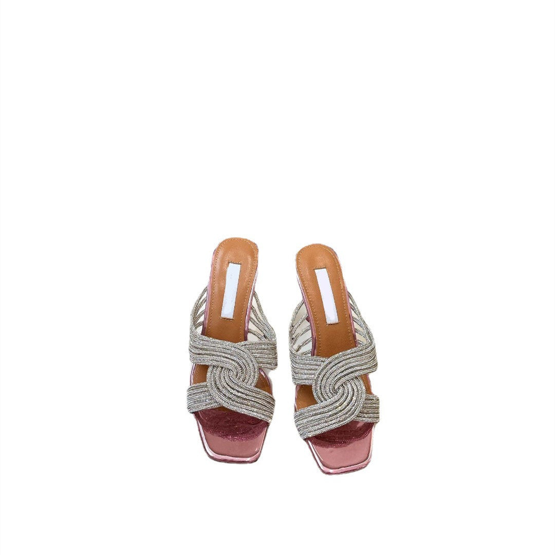 Pair of woven sandals with pink soles on a white background