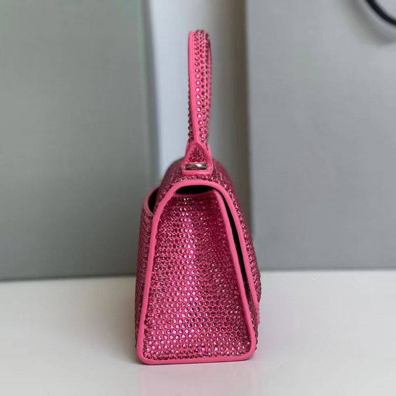 Pink handbag with textured surface on a white surface with gray background