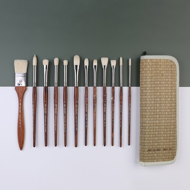 Set of paintbrushes with a woven case on a gray background