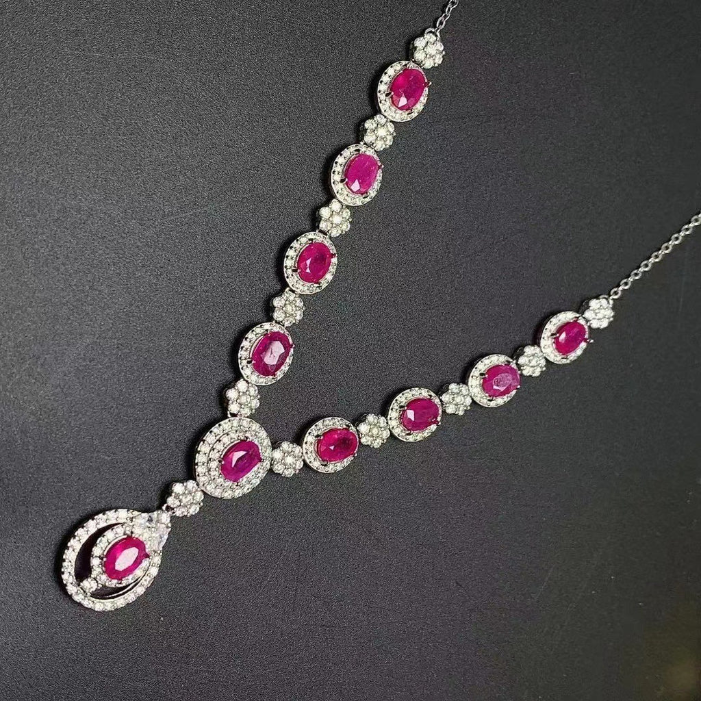 Necklace with pink gemstones and silver chain on a dark background