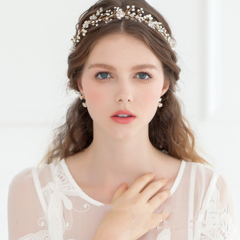 Woman wearing a decorative headpiece and earrings on a white background