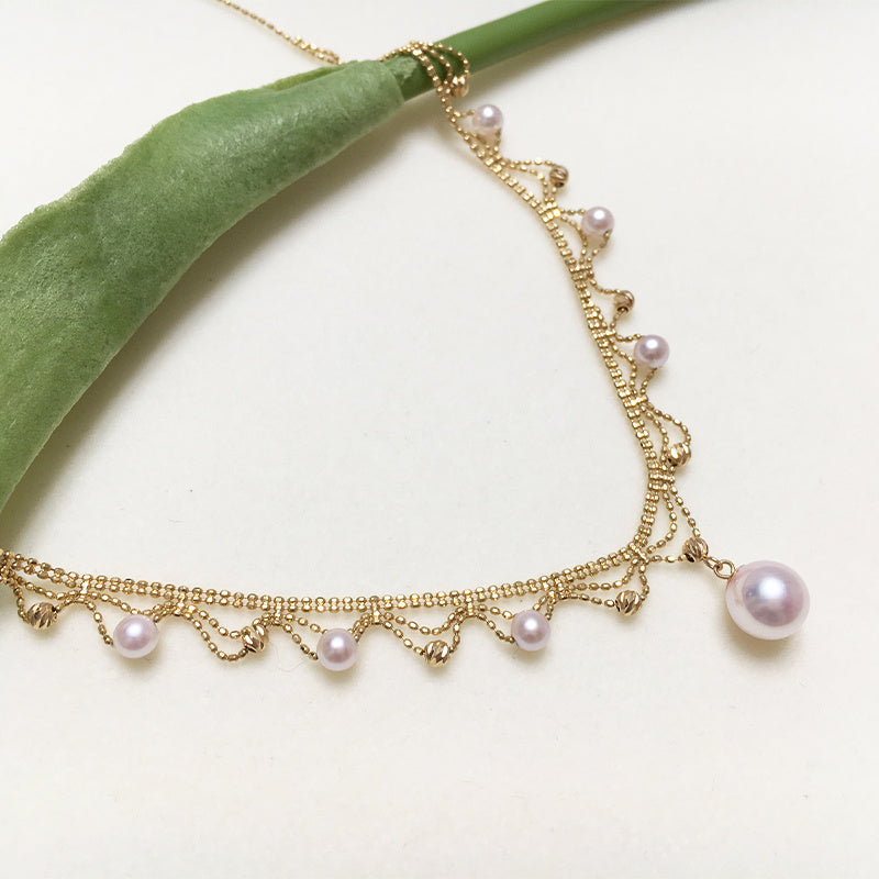 Gold necklace with pearls on a white background