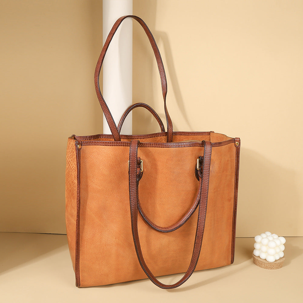 Brown leather tote bag on a beige background