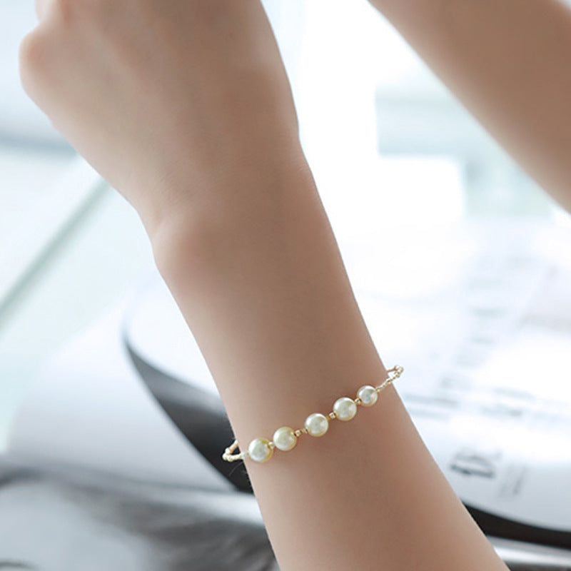 Pearl bracelet on a wrist with a blurred background