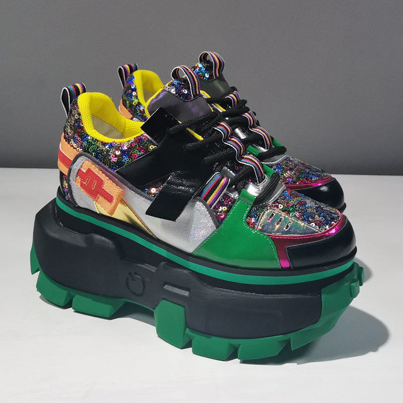 Colorful sneakers with a thick green sole on a gray background
