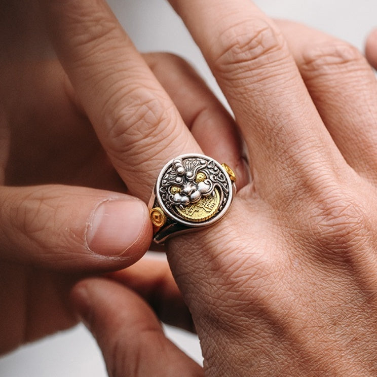 Close-up of a hand wearing a detailed ring with gold and silver elements.