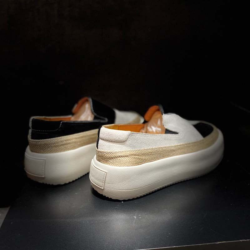 Pair of slip-on shoes with a white sole and beige side strip on a dark background