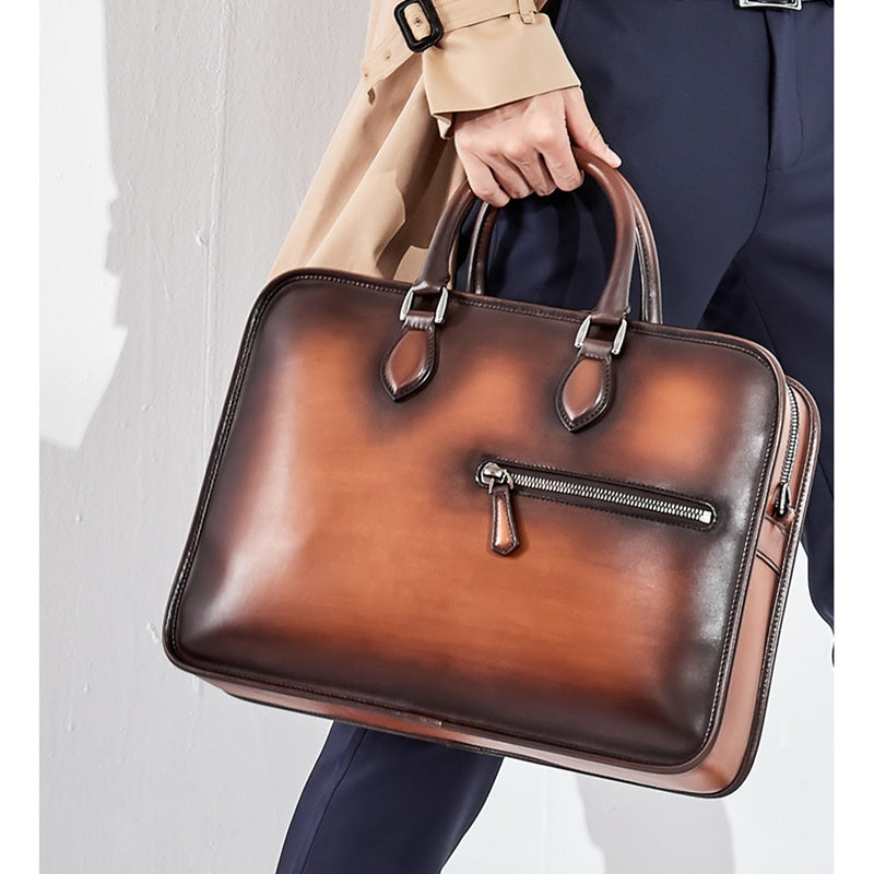 Brown leather briefcase held by a person wearing a trench coat and suit.