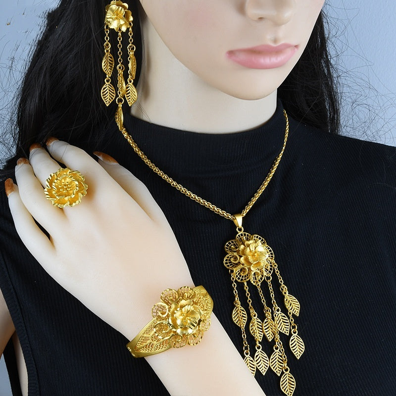 Mannequin wearing a gold jewelry set including necklace, earrings, and bracelet.