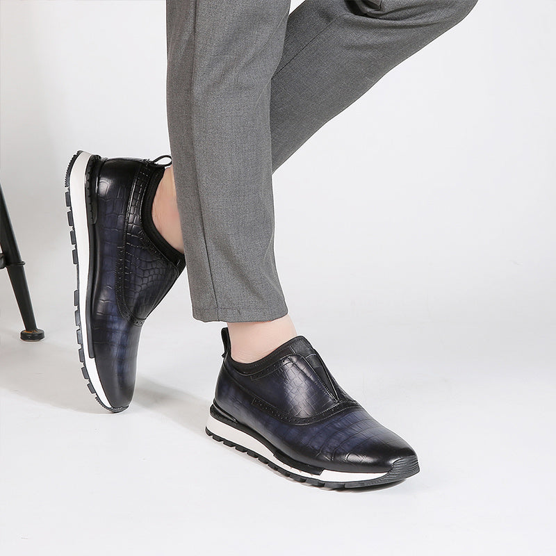 Black leather shoes worn with gray pants on a white background