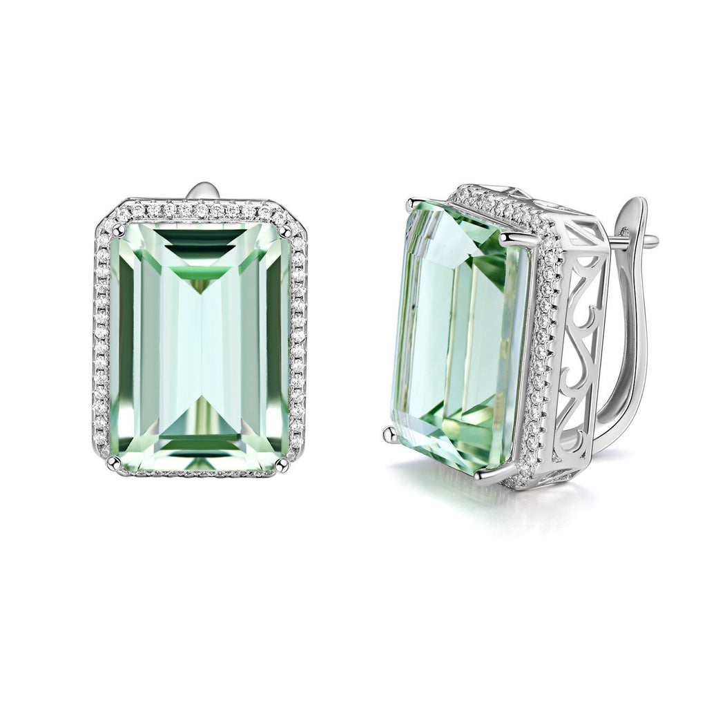 Pair of earrings with green gemstones and silver settings on a white background