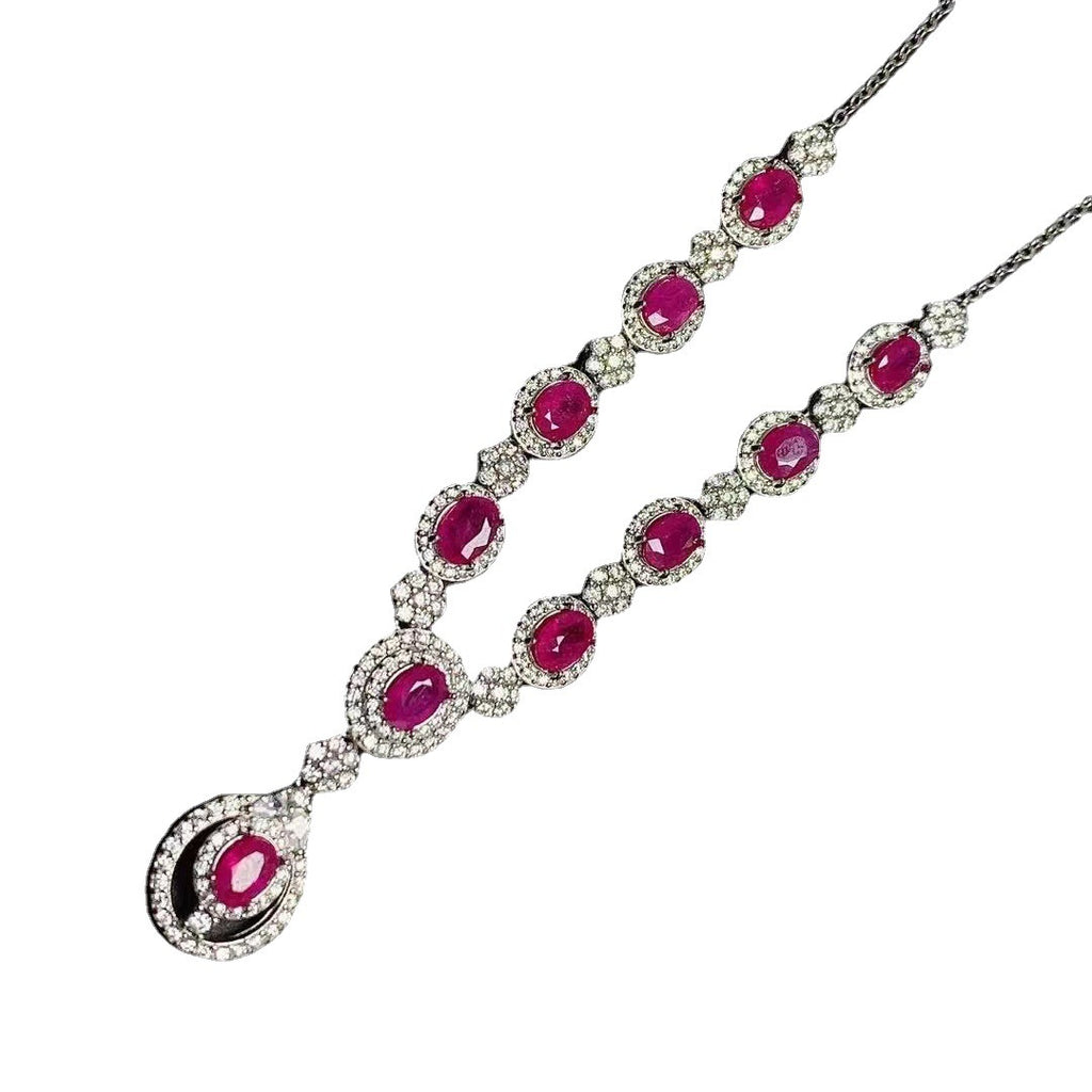Elegant necklace with red gemstones and white accents on a white background