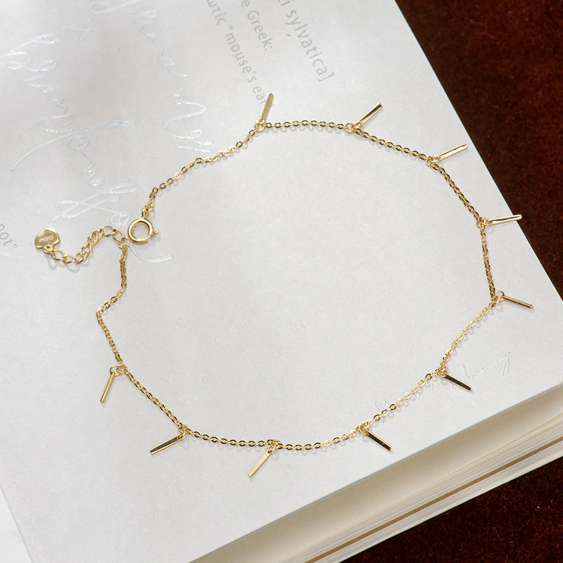 Gold bracelet with geometric design on a white surface