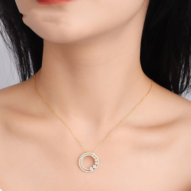 Gold necklace with a circular pendant on a model