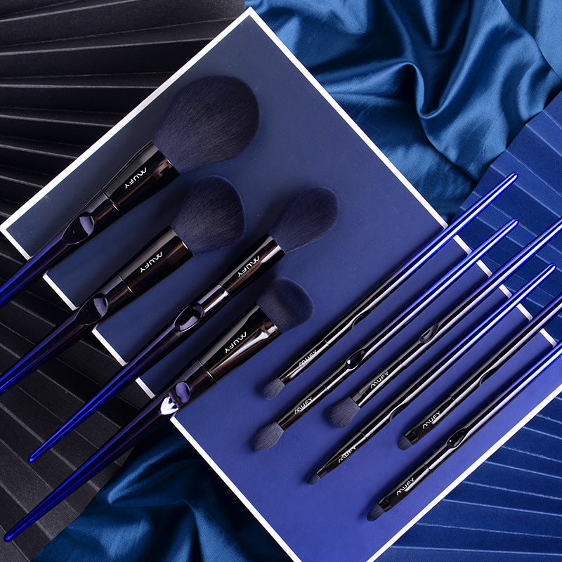 Set of makeup brushes in a blue case on a blue fabric background