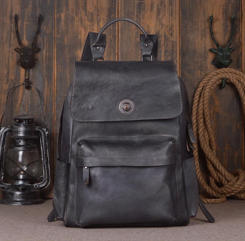 Black leather backpack on a wooden floor with rustic decor